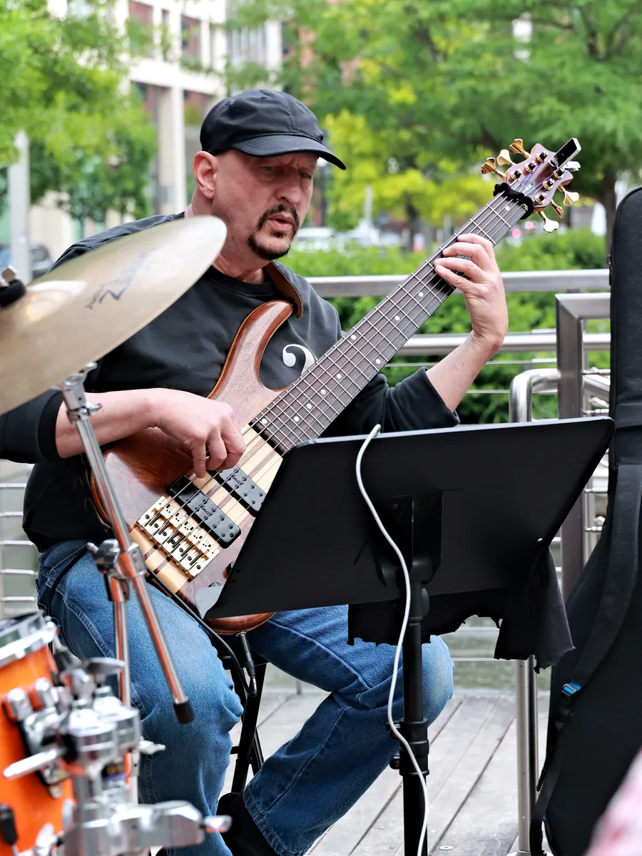 Russ Rodgers playing bass at an outdoor daytime performance