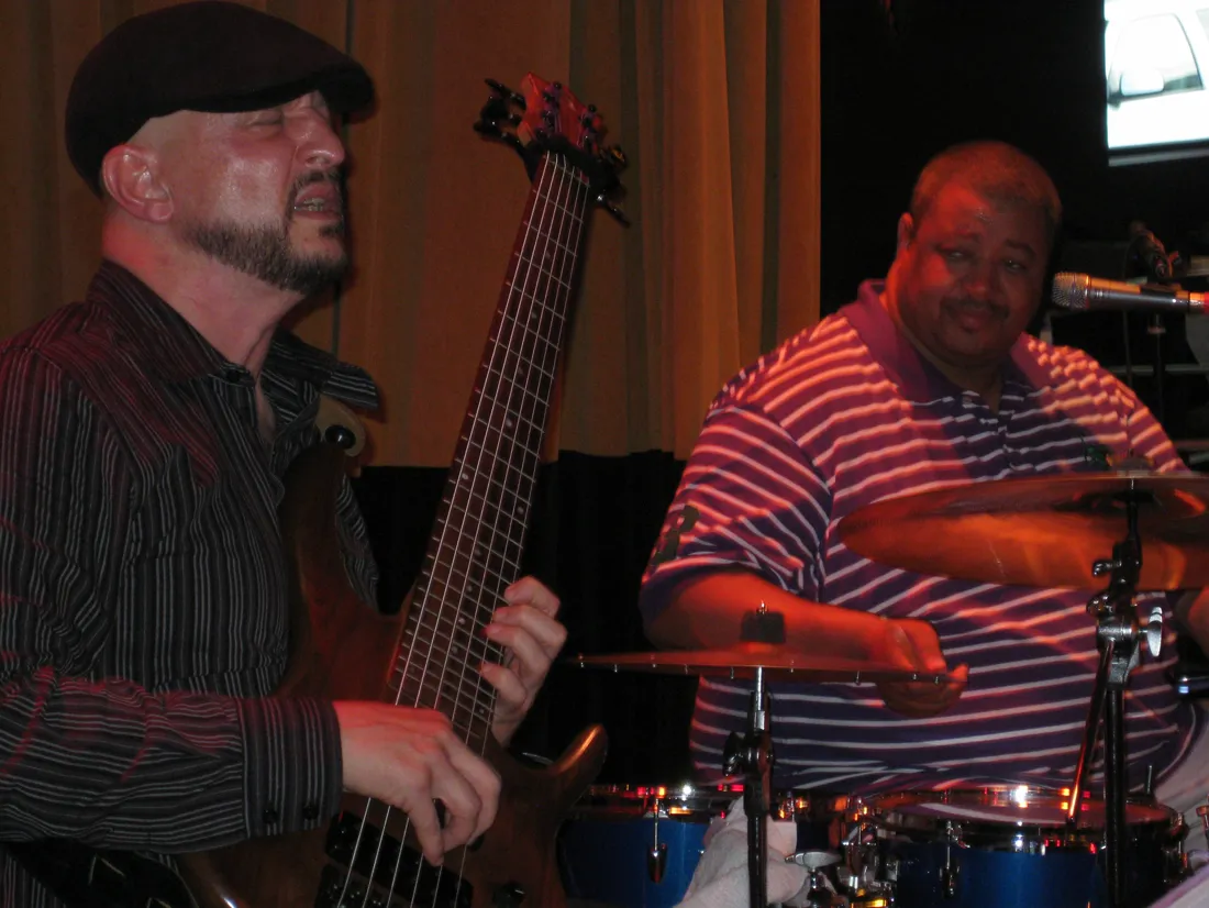 Russ Rodgers playing bass alongside a drummer during a live set